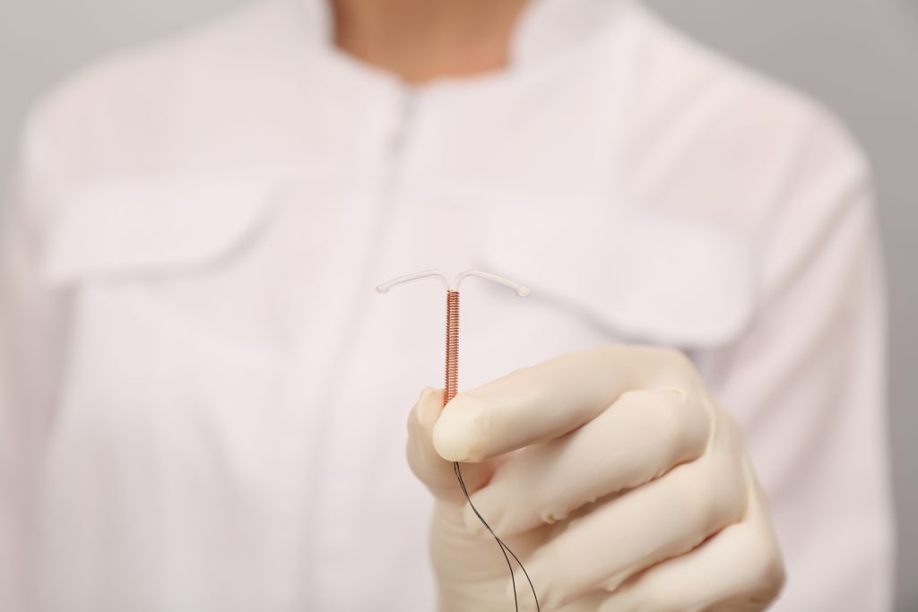 Doctor holding T-shaped intrauterine birth control device