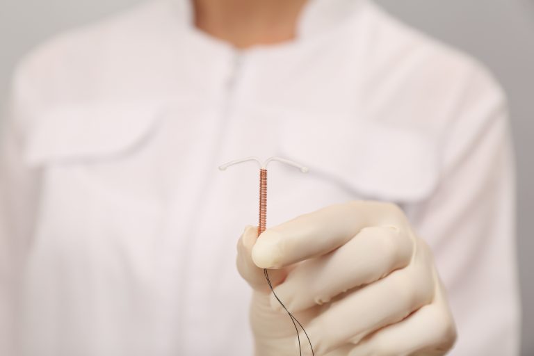 Doctor holding T-shaped intrauterine birth control device